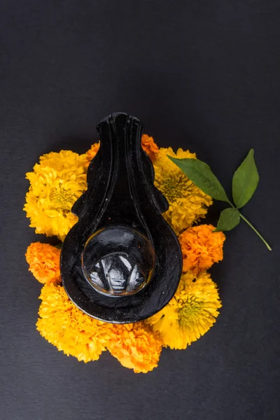 Shiva Linga compuesta de piedra negra decorada con flores y hoja de bael conocida como Aegle marmelos, sobre fondo negro, maha shiva ratri un festival de Dios hindú shankar o shankar bhagwan o bholenath —  Fotos de Stock