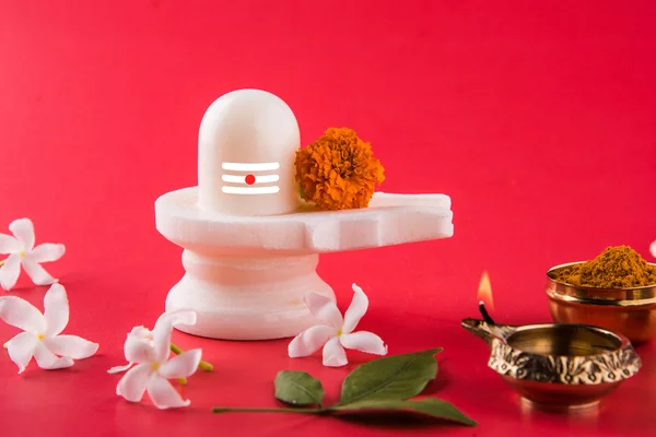 Shiva Linga compuesta de piedra negra decorada con flores y hoja de bael conocida como Aegle marmelos, sobre fondo negro, maha shiva ratri un festival de Dios hindú shankar o shankar bhagwan o bholenath —  Fotos de Stock