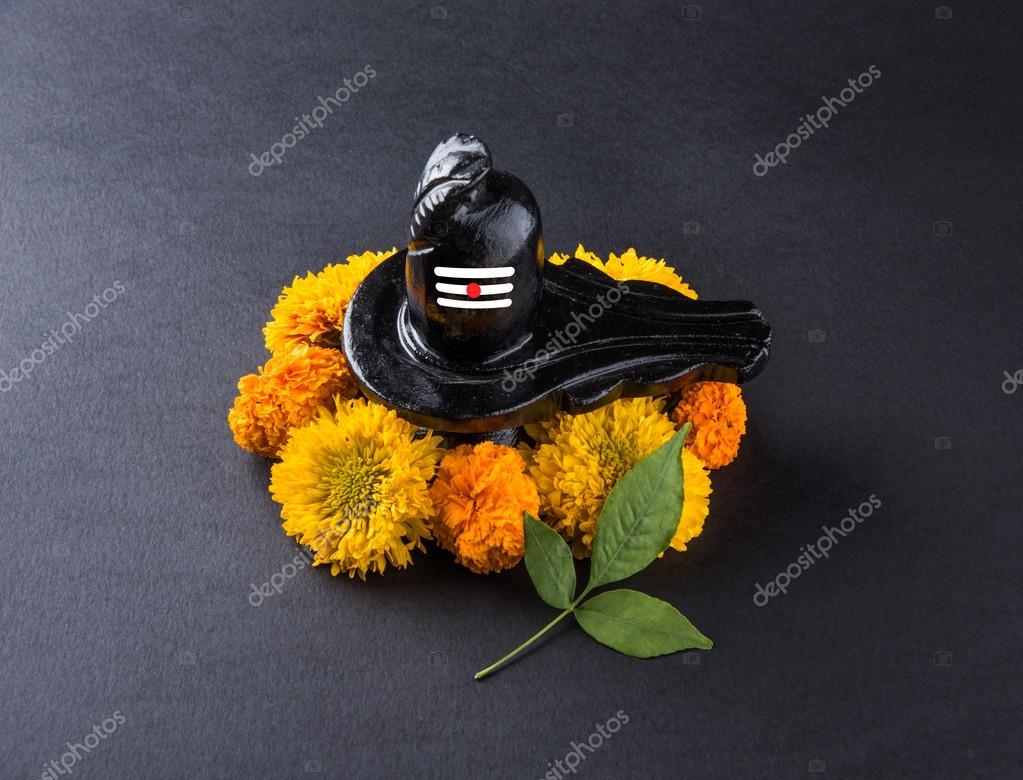 Shiva Linga made up of black stone decorated with flowers & bael leaf known  as Aegle