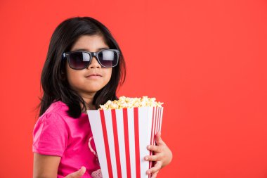 mutlu kız patlamış mısır yeme ve gözlük takan, hint kız patlamış mısır, asyalı kız ve patlamış mısır, kırmızı arka plan üzerinde patlamış mısır yeme hint kız
