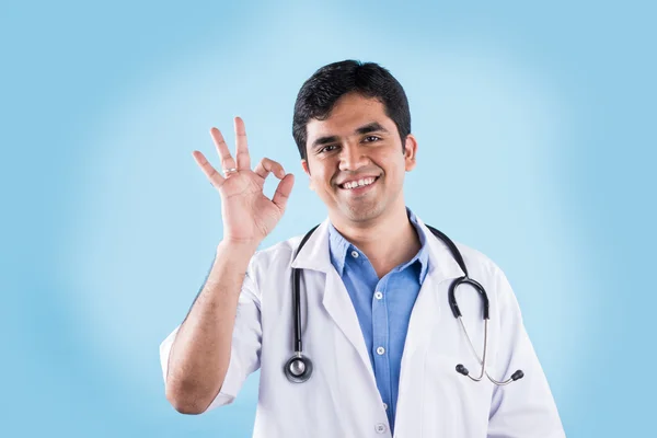 Ινδικό νεαρό αρσενικό γιατρό δείχνει OK πινακίδα, χαμογελαστός Ινδός γιατρός και OK πινακίδα, Ασιάτης/ισσα γιατρός δείχνει OK πινακίδα — Φωτογραφία Αρχείου