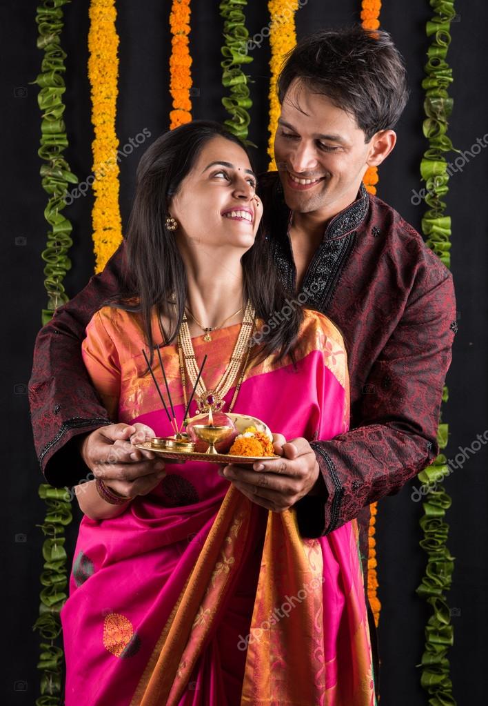 Smart indian couple in traditional wear performing gudhi padwa puja, asian  couple & puja thali, indian young couple with puja or pooja thali, hindu  new year gudhi / gudi padwa, isolated Stock