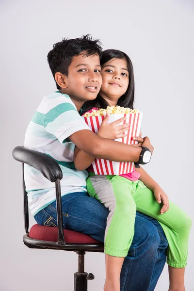 Olika stämningar medan små indiska flicka barn och pojke äter popcorn — Stockfoto