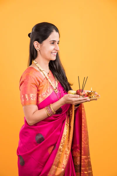 Mujer india realizando puja, chica india con pooja thali o puja thali, retrato de una hermosa joven con pooja thali, aislado sobre fondo amarillo — Foto de Stock