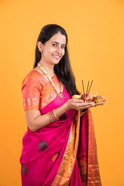 Mujer india realizando puja, chica india con pooja thali o puja thali, retrato de una hermosa joven con pooja thali, aislado sobre fondo amarillo — Foto de Stock