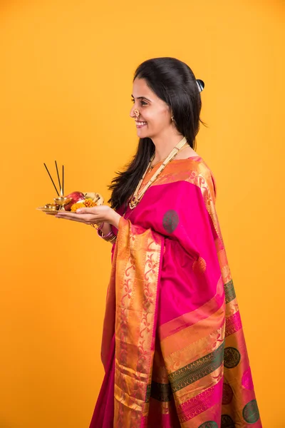 Mujer india realizando puja, chica india con pooja thali o puja thali, retrato de una hermosa joven con pooja thali, aislado sobre fondo amarillo — Foto de Stock