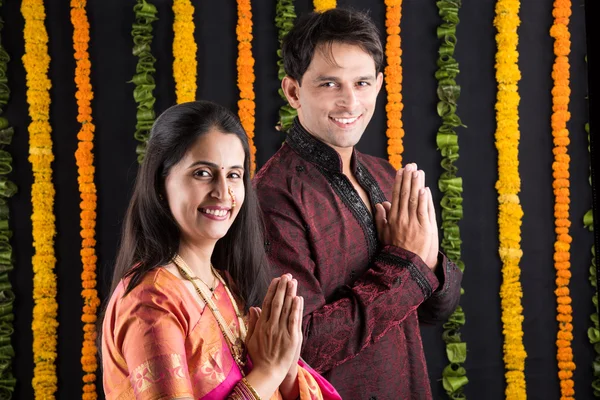 Portrait of Maharashtrian couple holding a puja thali, indian couple holding puja thali or pooja thali, indian couple celebrating diwali, laxmi pujan, asian couple and puja thali, couple doing prayer