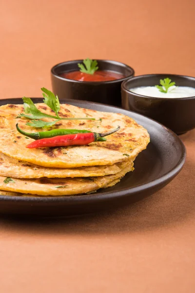 Традиционный индийский хлеб - Aloo paratha или aalu parotha, картофельный фаршированный хлеб. подается с томатным кетчупом или соусом с творогом — стоковое фото
