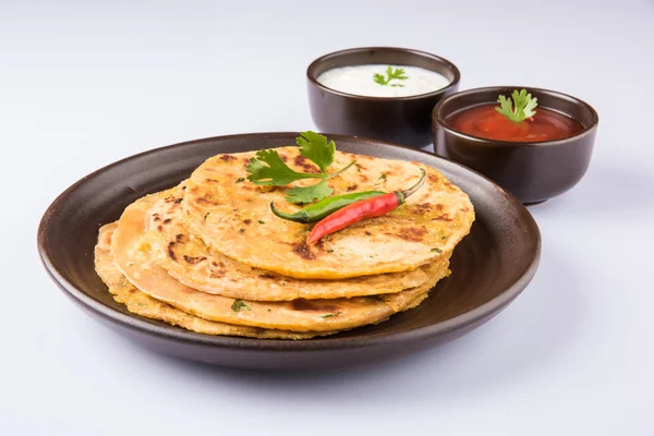 Traditionella indiska bröd - Aloo paratha eller Jennie parotha, potatis fyllda bröd. serveras med tomatketchup eller sås och ostmassa — Stockfoto