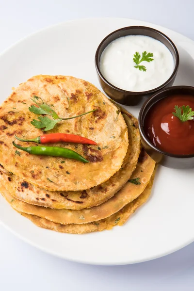 Traditionella indiska bröd - Aloo paratha eller Jennie parotha, potatis fyllda bröd. serveras med tomatketchup eller sås och ostmassa — Stockfoto