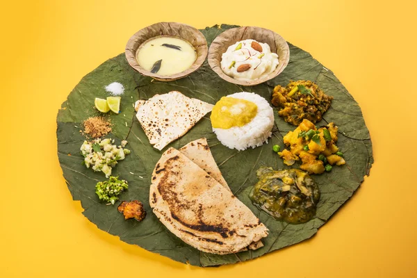 Typische maharashtrian eten geserveerd in plaat en kommen gemaakt van blad bevat kadhi en shrikhand, gewoon dal, spinazie curry, aalu mutter, witte rijst, papad, bhakri of bhakar of roti en verscheidenheid van salade — Stockfoto