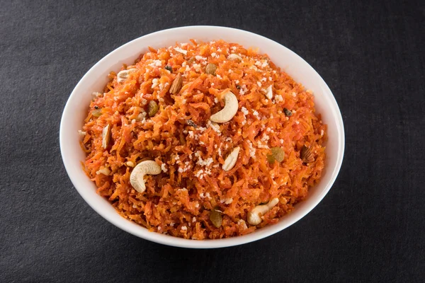 Saboroso gajar halwa ou gajar ka halwa composta ou cenoura fresca, açúcar e leite. decorados com amêndoa ou badam, castanha de caju e pistache, sobremesa norte-indiana favorita geralmente servida em casamentos — Fotografia de Stock