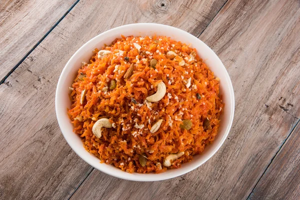 Saboroso gajar halwa ou gajar ka halwa composta ou cenoura fresca, açúcar e leite. decorados com amêndoa ou badam, castanha de caju e pistache, sobremesa norte-indiana favorita geralmente servida em casamentos — Fotografia de Stock