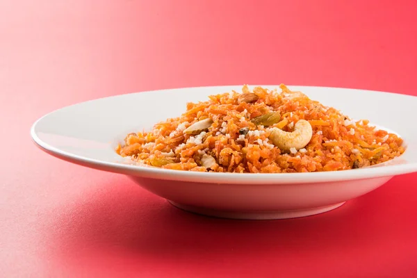 Saboroso gajar halwa ou gajar ka halwa composta ou cenoura fresca, açúcar e leite. decorados com amêndoa ou badam, castanha de caju e pistache, sobremesa norte-indiana favorita geralmente servida em casamentos — Fotografia de Stock