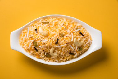 Hindistan cevizi pirinç, pilav hindistan cevizi tatlı, tatlı Hindistan cevizi pirinç olarak da bilinen narali bhat marathi, favori Hint tatlı, konkan gıda, kerala gıda, safran, kaju, karanfil, beyaz kase içinde izole hizmet