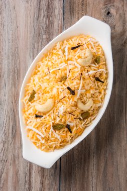 Hindistan cevizi pirinç, pilav hindistan cevizi tatlı, tatlı Hindistan cevizi pirinç olarak da bilinen narali bhat marathi, favori Hint tatlı, konkan gıda, kerala gıda, safran, kaju, karanfil, beyaz kase içinde izole hizmet