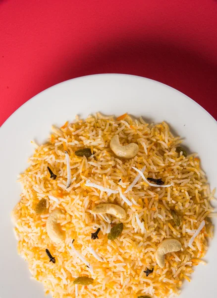 Кокосовый рис, кокосовый сладкий рис, сладкий кокосовый рис, также известный как Нарали бхат в маратхи, любимый индийский сладкий, конкан пищи, керала пищи, шафран, кешью, гвоздика, подается в белой миске, изолированные — стоковое фото