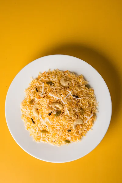 Ρύζι καρύδας, καρύδα γλυκιά ρυζιού, γλυκό καρύδα ρύζι επίσης γνωστή ως narali μπατ σε Μαράθι, αγαπημένο ινδική γλυκό, konkan τροφίμων, Κεράλα, σαφράν, κάσιους, γαρίφαλο, σερβίρεται σε λευκά μπολ, απομονωμένη — Φωτογραφία Αρχείου