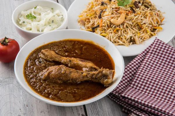 O caril de frango avermelhado mais popular no Reino Unido, Índia, Paquistão, Ásia, frango tikka masala, aqui servido em tigela, acompanhado de arroz pilau e chapatis — Fotografia de Stock