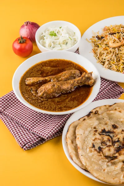 O caril de frango avermelhado mais popular no Reino Unido, Índia, Paquistão, Ásia, frango tikka masala, aqui servido em tigela, acompanhado de arroz pilau e chapatis — Fotografia de Stock