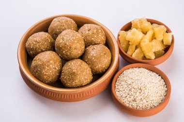 Hint susam tatlı veya tilgul laddu, jaggery ve susam oluşan, Makar Sankranti festivali için hint tatlı, jaggery & çiğ susam ile terracotta kase