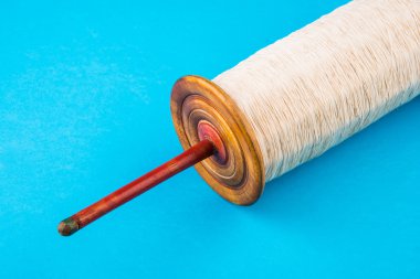 Uçurtma uçmak için beyaz iplik ile güzel bir iğ, mavi arka plan, seçici odak izole