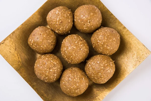 Le sésame indien sucré ou tilgul laddu, composé de graines de jaggery et de sésame, sucré indien pour le festival Makar Sankranti, dans un bol en terre cuite avec jaggery et sésame cru — Photo