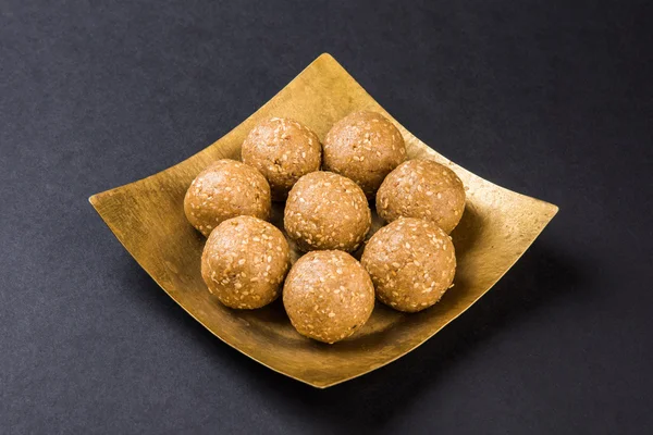 마카르 산크란티 축제를 위한 인도의 달콤한, 재기와 생 참깨를 곁들인 테라코타 그릇에 담긴 인도 참깨 스위트 또는 틸굴 라두 — 스톡 사진