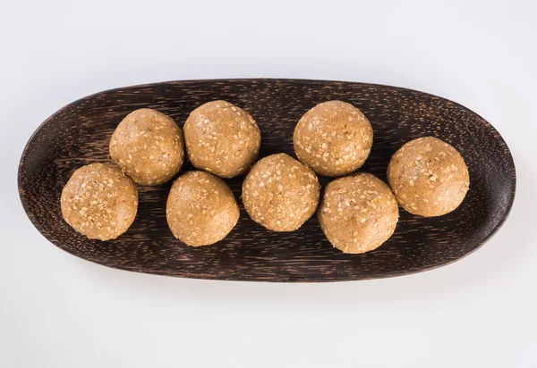 O gergelim indiano doce ou tilgul laddu, composto por jaggery e sementes de gergelim, doce indiano para o festival Makar Sankranti, em tigela de terracota com jaggery & gergelim cru — Fotografia de Stock