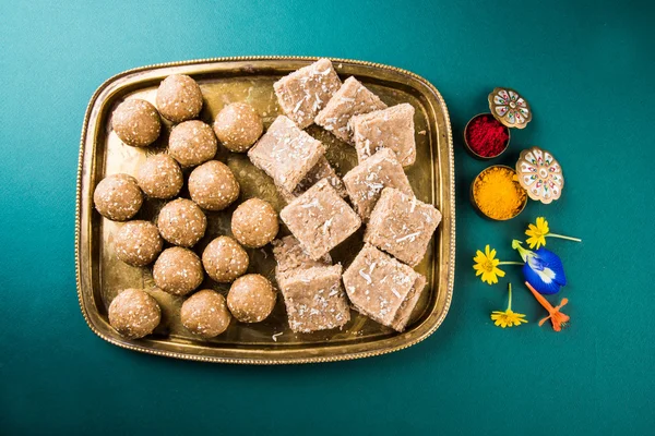 Sésamo laddu o tulgul o til gul laddu o ladu en plato de latón con huldi y kumkum, festival tradicional indio en enero, comida dulce india, rituales indios, pastel tilgul o vadi — Foto de Stock