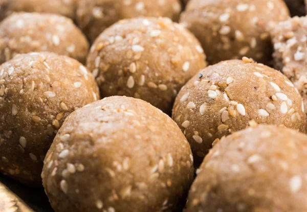 Sesamleiter oder Tüll oder til gul laddu oder ladu in Messingplatte mit Hüldi und Kumkum, traditionelles indisches Fest im Januar, indische Süßspeisen, indische Rituale, Tilgul-Kuchen oder Vadi — Stockfoto