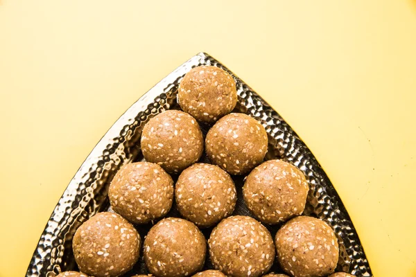 The indian sesame sweet or tilgul laddu or til gul laddu, made up of jaggery and sesame seeds, hand made, round, indian sweet prepared in Makar Sankranti festival