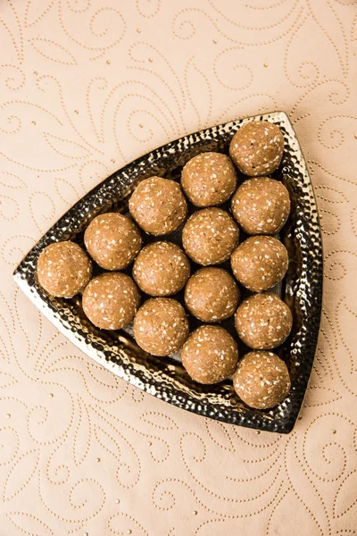 The indian sesame sweet or tilgul laddu or til gul laddu, made up of jaggery and sesame seeds, hand made, round, indian sweet prepared in Makar Sankranti festival