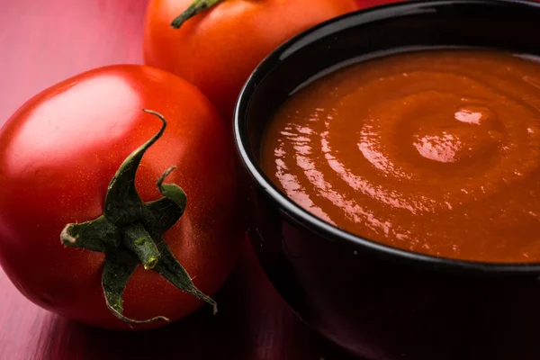 Gospodarstwo świeżych pomidorów i puree, pomidorów z sosem, czerwony pomidor i wklej — Zdjęcie stockowe