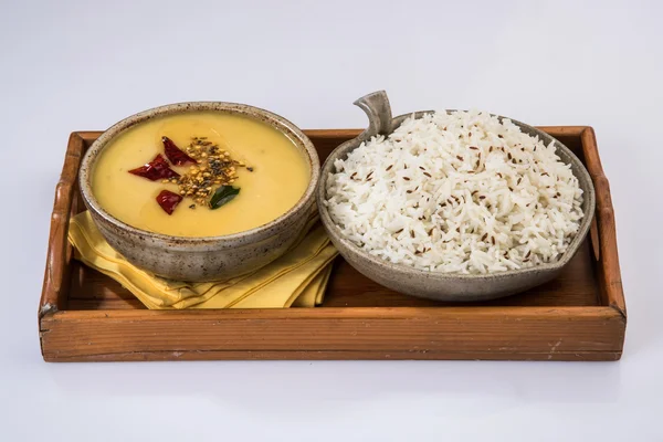 Whole Yellow Lentil with Rice, dal tadka and jeera rice, Indian Dish, cooked rice and cooked Arhar or Toor dal (Pigeon Pea), served in ceramic bowl, on green mat