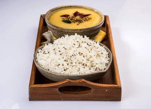 Gehele gele linzen met rijst, dal tadka en jeera rijst, Indiase schotel, gekookte rijst en gekookte Arhar of Toor dal (Duif Erwt), geserveerd in keramische kom, op groene mat — Stockfoto