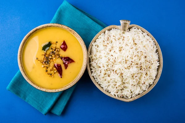 Lenteja amarilla entera con arroz, tadka dal y arroz jeera, plato indio, arroz cocido y Arhar cocido o Toor dal (guisante de paloma), servido en tazón de cerámica, en estera verde — Foto de Stock