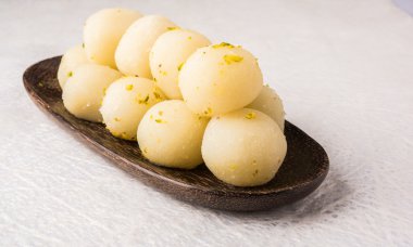 Bangladeş veya Hindistan'ın en sevdiği tatlı rasgulla, Kuru rasgulla, bengal tatlılar, sütünden yapılmıştır / khoya, tatlı karşılar, kavisli bir çelik plaka, aşırı closeup, ön açısı