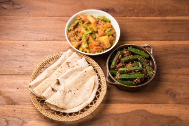 bhindi masala veya bhendi masala veya hint roti / chapati / fulka / paratha / hint ekmeği, hint baharatlı gıda ile kırmızı köri karışık sebze ile bayanlar parmak kızartma