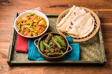 bhindi masala veya bhendi masala veya hint roti / chapati / fulka / paratha / hint ekmeği, hint baharatlı gıda ile kırmızı köri karışık sebze ile bayanlar parmak kızartma