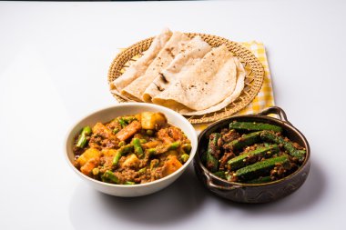 bhindi masala veya bhendi masala veya hint roti / chapati / fulka / paratha / hint ekmeği, hint baharatlı gıda ile kırmızı köri karışık sebze ile bayanlar parmak kızartma