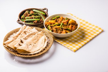 bhindi masala veya bhendi masala veya hint roti / chapati / fulka / paratha / hint ekmeği, hint baharatlı gıda ile kırmızı köri karışık sebze ile bayanlar parmak kızartma