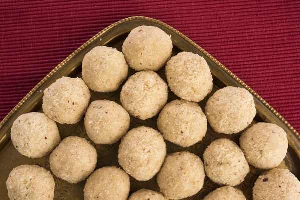 Many coconut sweet laddus stacked in a brass plate, extreme closeup — Stock Photo, Image