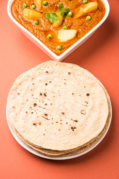Potato curry or aalu masala or aaloo masala with green peas, served with indian bread / roti / chapati / naan / fulka / phulka — Stock Photo, Image