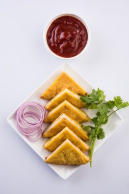 Ekmek Pakora veya ekmek pakoda domates ketçap yeşil soğuk ve soğan dilimleri ile birlikte servis, hint çerez, yeşil paspas üzerinde beyaz tabakta servis, izole ön görünüm, beyaz arka plan