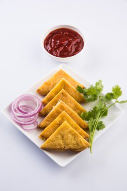 Ekmek Pakora veya ekmek pakoda domates ketçap yeşil soğuk ve soğan dilimleri ile birlikte servis, hint çerez, yeşil paspas üzerinde beyaz tabakta servis, izole ön görünüm, beyaz arka plan