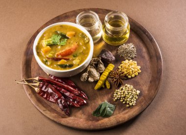 güney hint sebze sambar, kahverengi arka plan üzerinde ahşap plaka üzerinde ham baharatile, izole