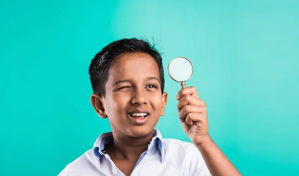 Niño indio feliz con lupa, niño asiático mirando a través de lupa con sonrisa, niño indio sosteniendo una lupa, niño indio o asiático jugando o posando con lupa — Foto de Stock