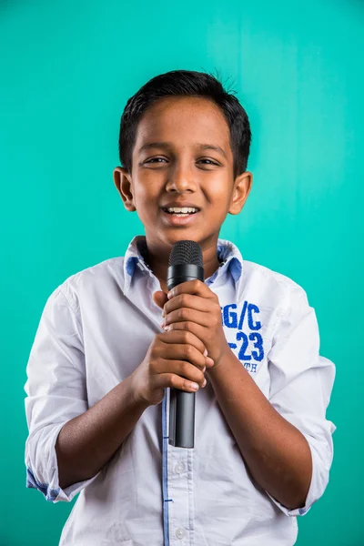 Young indian boy in white shirt yelling in microphone, little kid singing, Little indian boy with microphone sings a song, Singing asian Young boy, Cute young asian boy singing into a microphone — Stock Photo, Image