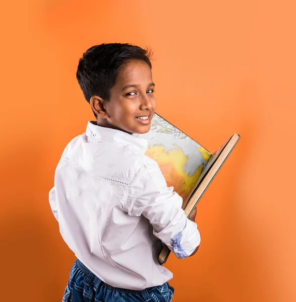 Indian kid enjoying reading book, asian kid reading book, african kid reading book, indian kid studying, indian kid holding book, portrait, indian kid standing with book, geography book, orange back — Stock Photo, Image